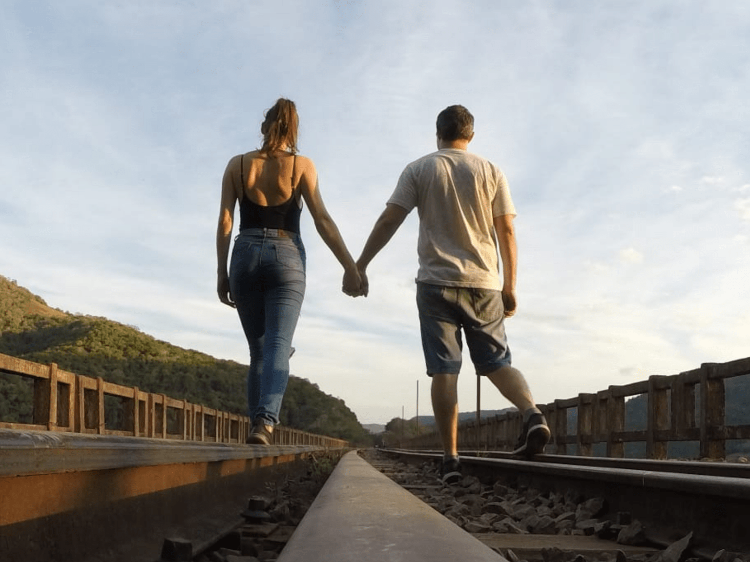 Casal caminhando de mãos dadas ao ar livre, simbolizando os desafios e o equilíbrio ao relacionar com quem tem TDAH.
